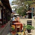 a street with tables and chairs and a sign on the street