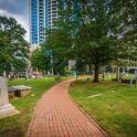 a brick path in a park with trees and benches
