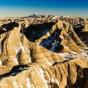 an aerial view of a desert with snow covered mountains