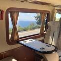 从房车后座看到的景色，有一张桌子和一扇窗户