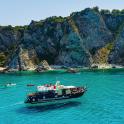 a boat in the water near a rocky island