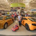 a woman and a child standing next to two cars