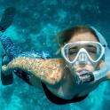 a woman wearing a snorkel and a gas mask in the water