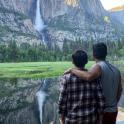 a man and a boy standing in front of a waterfall