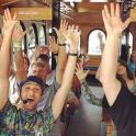 a group of people on a bus with their hands in the air