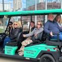 a group of people sitting in a golf cart