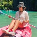 a woman sitting in a pink kayak in the water