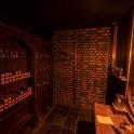 a dark room with a shelf of alcohol bottles