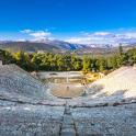 an empty amphitheater with mountains in the background
