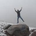 a man jumping over a rock in the snow
