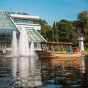 a boat in the water in front of a fountain