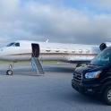 a car parked next to a plane on a runway