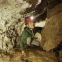 a young boy wearing a helmet in a cave