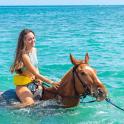 a young girl riding a horse in the water