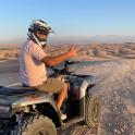 一名男子在沙漠中骑着四轮摩托车