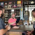 a group of men standing at a counter in a bar