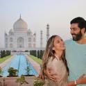 a man and a woman standing in front of the taj mahal