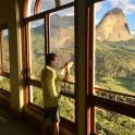 a man taking a picture of a mountain through a window
