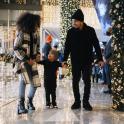 a family walking through a mall with a christmas tree