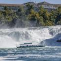 a group of people on a boat in front of a waterfall