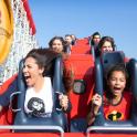 a group of people riding on a roller coaster at the theme park