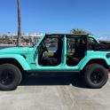 a green jeep parked in a parking lot