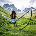 一位女士坐在田野里的吊床上