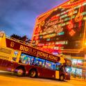 a double decker bus driving past a large building