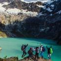 a group of people jumping in front of a lake