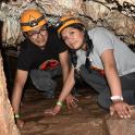 two people are posing for a picture in a cave