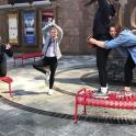 a group of women jumping on red benches