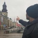 a man pointing at a clock tower in a city