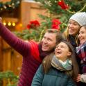 a group of people posing for a picture in front of a christmas tree