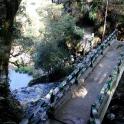 a wooden fence next to a river with a road