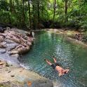 a man laying in the water in a river