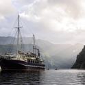 a boat in the water with mountains in the background