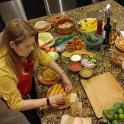 a woman standing at a kitchen counter preparing food