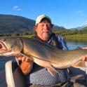 a man in a boat holding a large fish