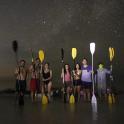 a group of people standing in the water with paddles