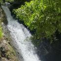 a waterfall on the side of a mountain with trees