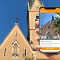 a person holding a cell phone in front of a church