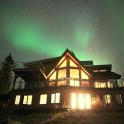 a house with the northern lights in the sky