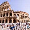 a group of people standing in front of the coliseum