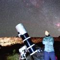 a man standing in front of a telescope