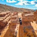 a truck driving through a canyon in the desert