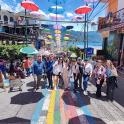a group of people walking down a street with a rainbow