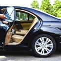 a man opening the door of a black car