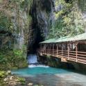 a bridge over a river next to a waterfall