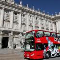 a red double decker bus parked in front of a building