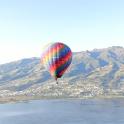 a colorful hot air balloon flying over a body of water